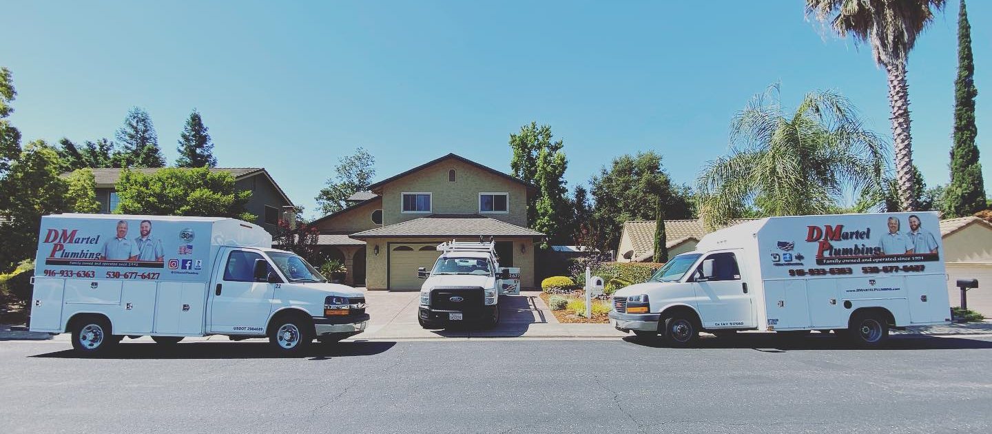 D. Martel Plumbing service trucks parked in front of a home
